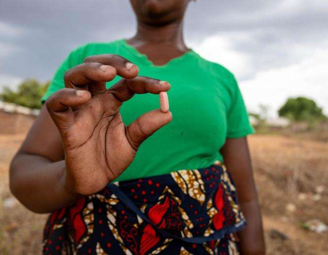 An MSF patient holds a pill as part of antiretroviral treatment for HIV in Mozambique.